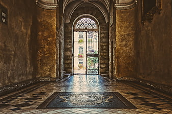 Historic European Hallway With Ornate Iron Gate And Mosaic Floor