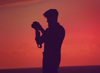 Silhouette of Photographer with Camera Against Vibrant Sunset