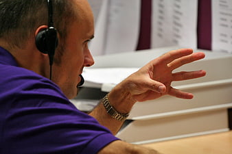 Man with headset gesturing in office environment