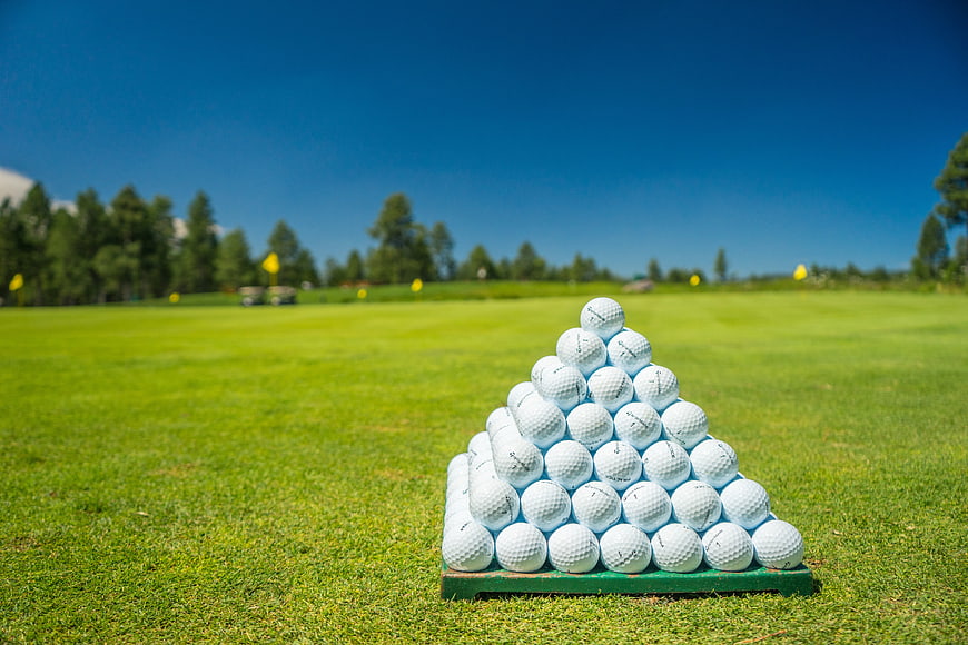 Pyramid Stack of Golf Balls on Green Course