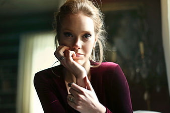 Pensive Woman in Burgundy Top with Rings