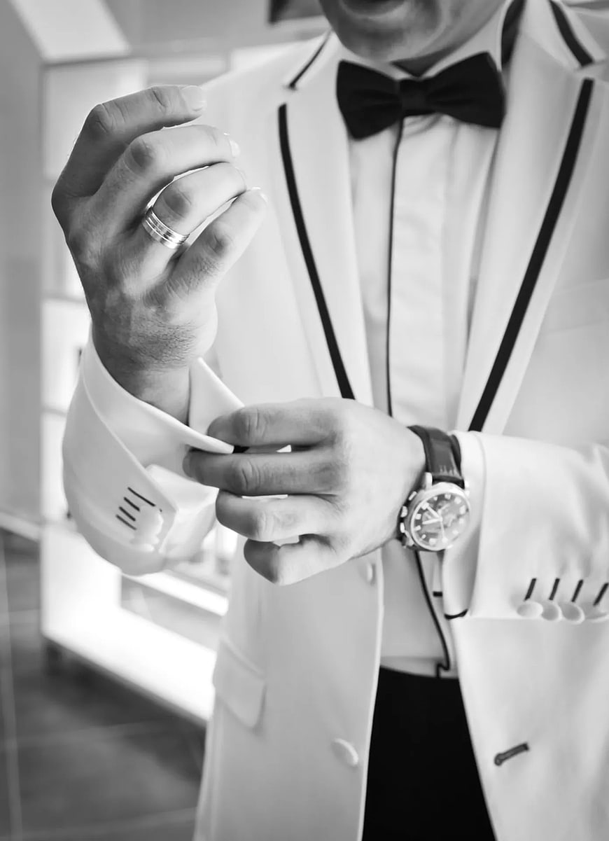 Man in White Tuxedo Adjusting Cufflinks and Watch