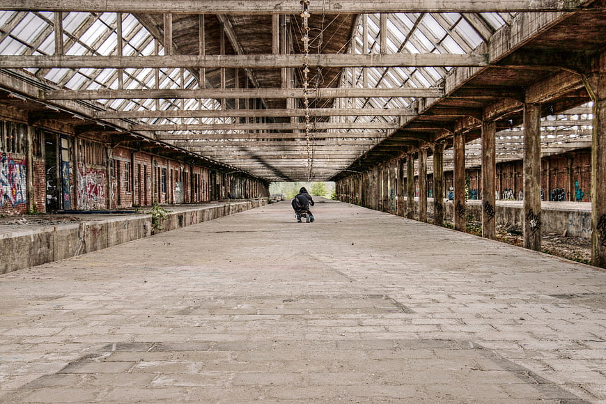 Skateboarder in Abandoned Industrial Hall with Graffiti