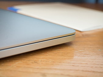 Close-up of silver laptop corner on wooden desk