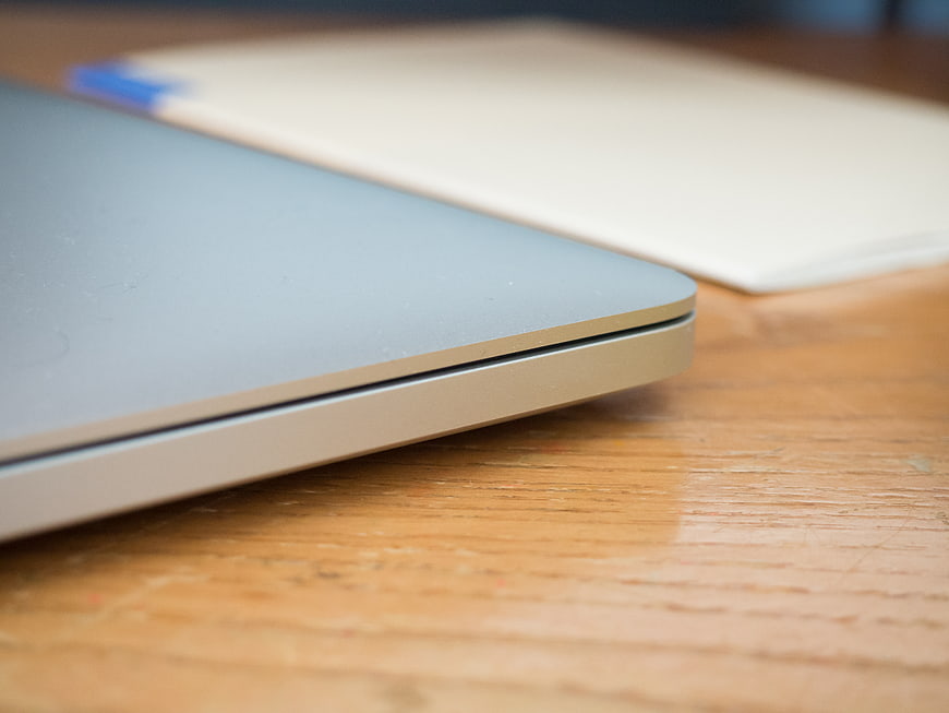 Close-up of silver laptop corner on wooden desk