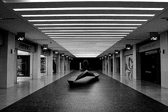 Black and white modern shopping mall corridor with geometric sculpture