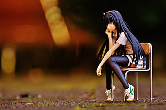 Anime Figure of Girl Sitting on Chair in Park