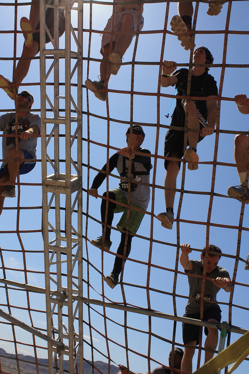 Athletes Climbing Cargo Net Obstacle Course