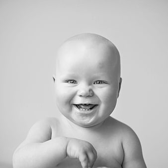 Black and white portrait of a smiling baby with a single tooth