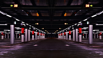 Empty underground parking garage with red and white pillars