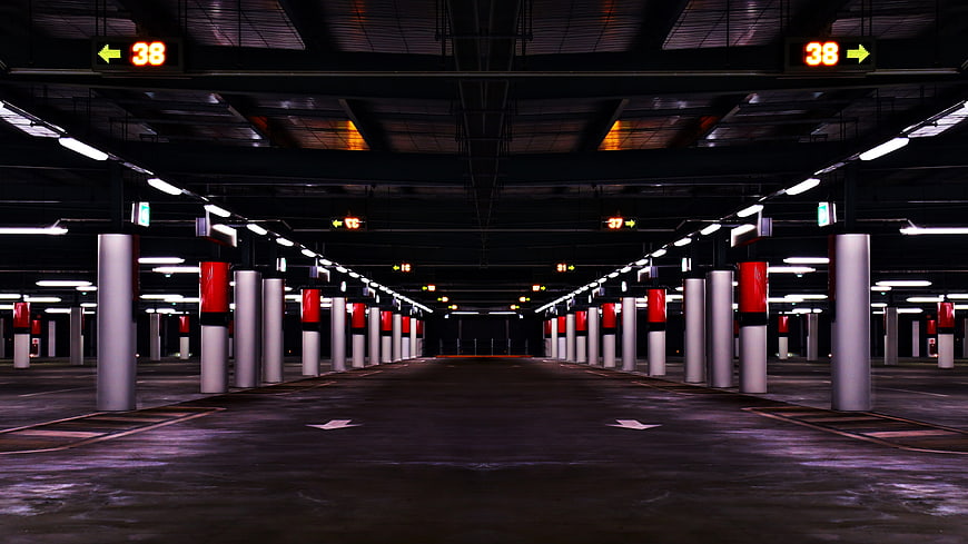 Empty underground parking garage with red and white pillars