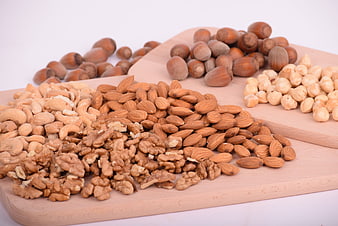 Assorted raw nuts on wooden cutting boards