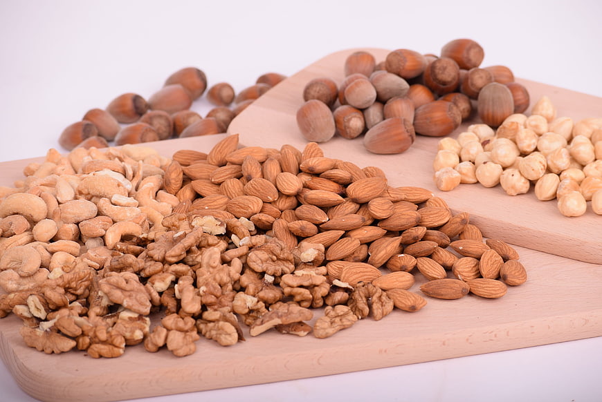 Assorted raw nuts on wooden cutting boards