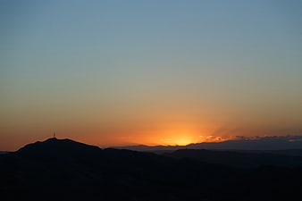 Silhouette of Mountains Against a Vibrant Sunset Sky