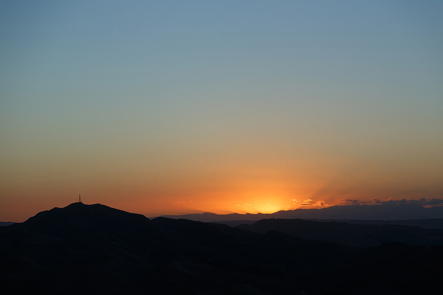 Silhouette of Mountains Against a Vibrant Sunset Sky