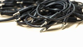 Coiled Black Audio Cables With 3.5mm Jacks On White Surface