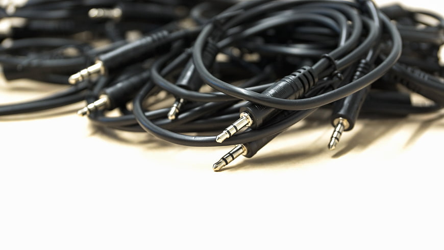 Coiled Black Audio Cables With 3.5mm Jacks On White Surface