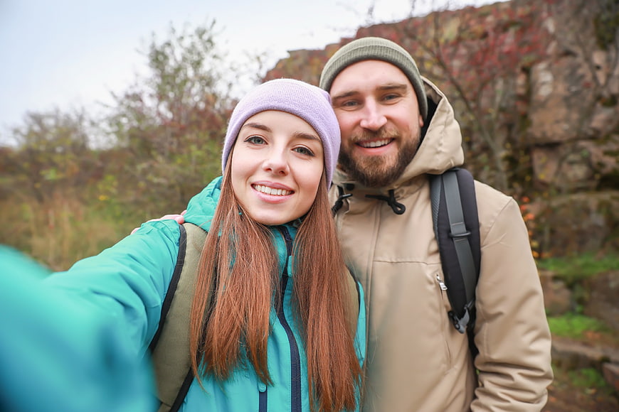 Happy couple taking a hiking selfie in autumn nature