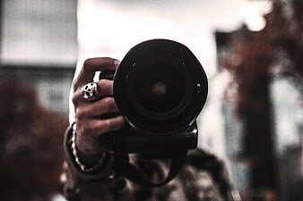 Close-up of Photographer Holding Camera Lens