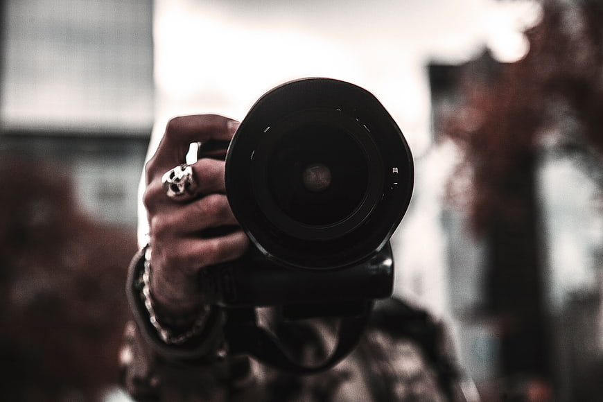 Close-up of Photographer Holding Camera Lens