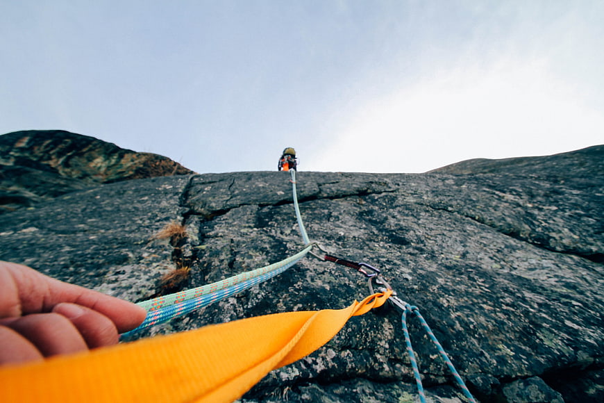 First-person view of rock climbing gear on granite cliff