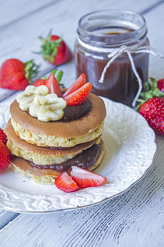 Stacked Pancakes With Chocolate Spread, Banana, And Fresh Strawberries