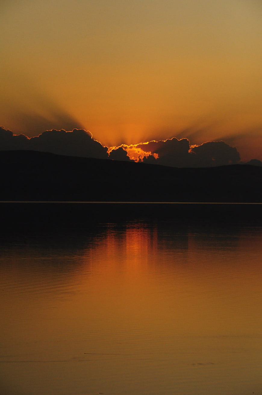 Dramatic Sunset Over Lake with Clouds and Reflections