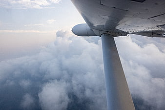 Airplane wing view above clouds during flight
