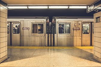 Two subway trains stopped at an underground station platform