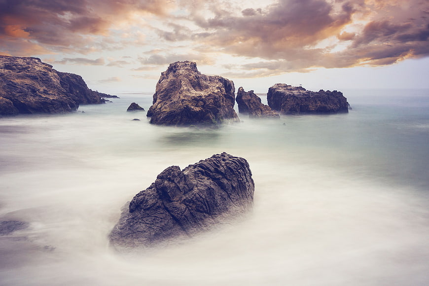 Dramatic long exposure coastal seascape with misty water and rock formations