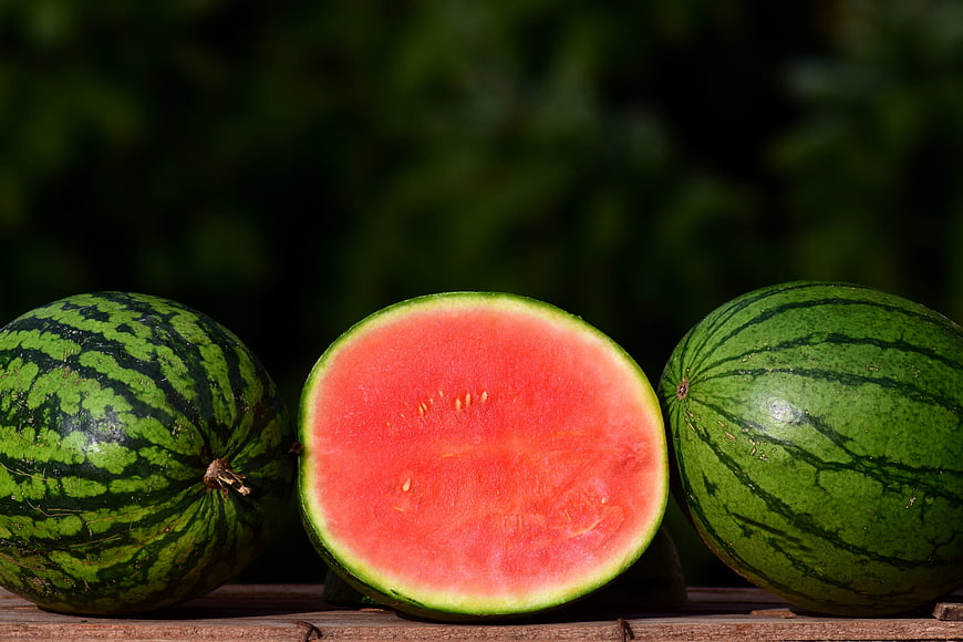 Fresh Watermelons with Vibrant Red Flesh on Wooden Surface