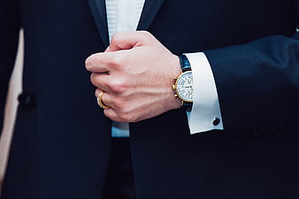 Close-up of man in tuxedo with luxury watch and wedding ring