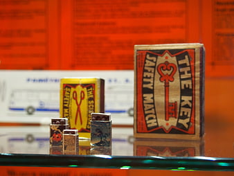 Vintage matchboxes with key and scissors designs on display
