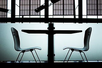 Silhouette of two chairs and table against frosted window
