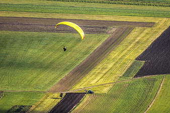 Aerial View of Paraglider Over Green Agricultural Fields