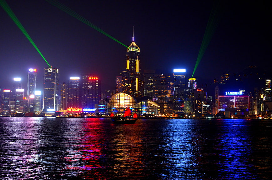 Hong Kong Victoria Harbour Night Skyline With Green Laser Beams And Water Reflections