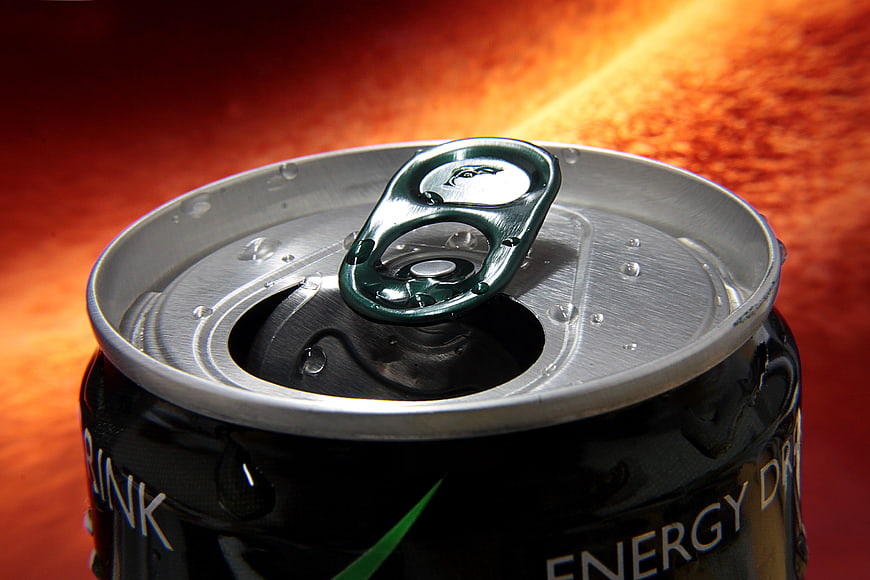 Close-up of an open black energy drink can with condensation