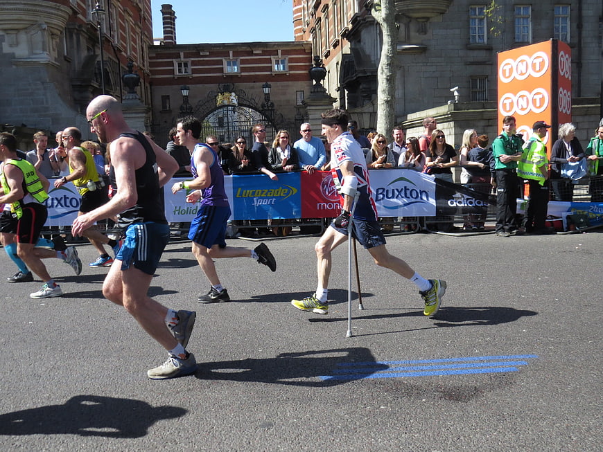 Paralympic runner with prosthetic legs competing in a city marathon race