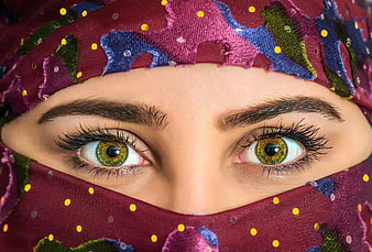 Close-up portrait of a woman's eyes wearing a colorful patterned headscarf