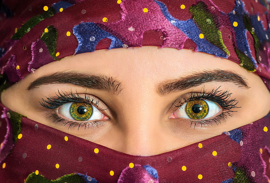 Close-up portrait of a woman's eyes wearing a colorful patterned headscarf