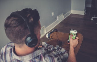 Man with headphones using smartphone on floor