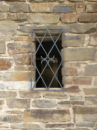 Old stone wall with small barred window