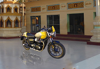 Yellow Triumph Motorcycle Parked in Front of Burmese Temple
