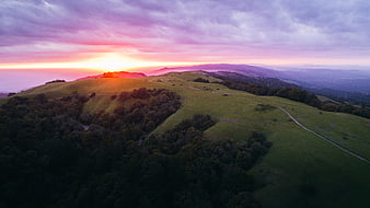 Aerial View of Rolling Green Hills at Vibrant Sunset