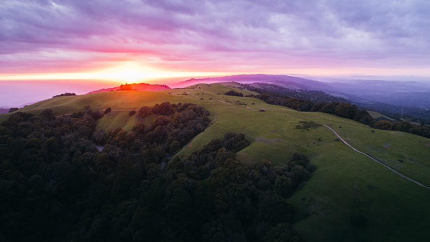 Aerial View of Rolling Green Hills at Vibrant Sunset