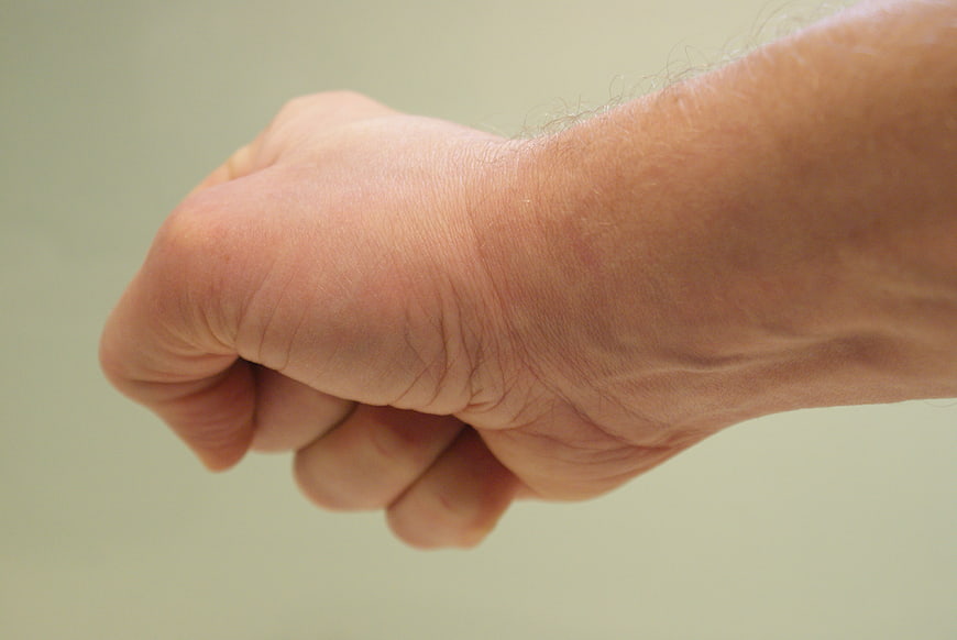Close-up of a clenched human fist showing tension and stress