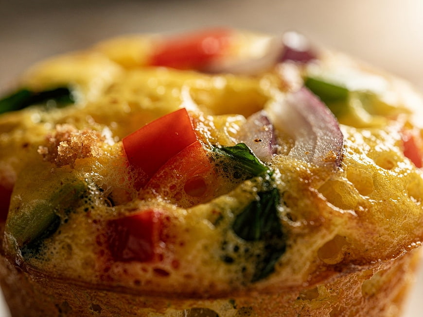 Close-up of savory vegetable egg muffin with peppers and onions