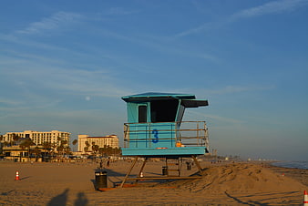 Blue Lifeguard Tower on Sandy Beach at Sunset