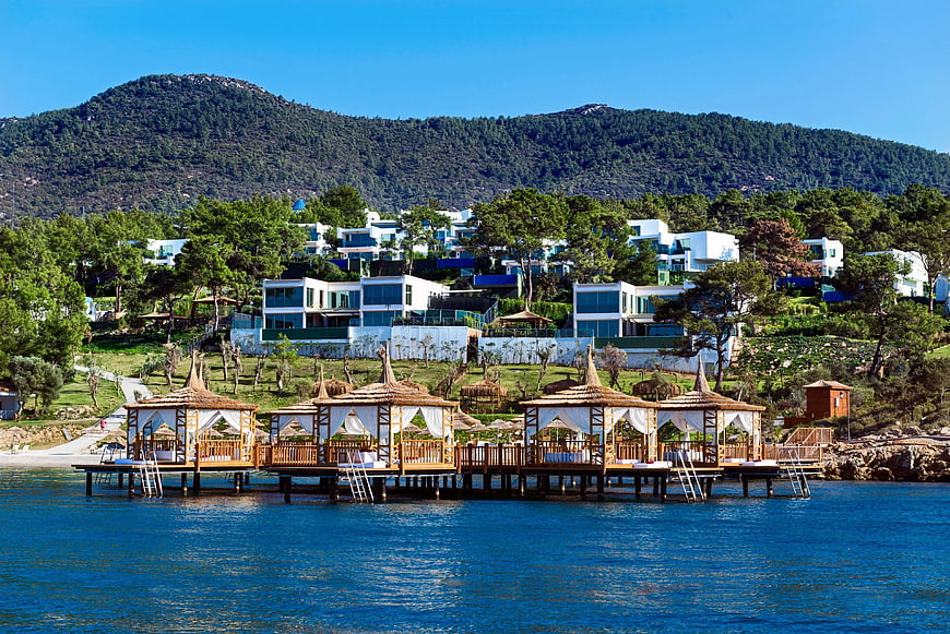Luxury overwater cabanas with modern villas on hillside