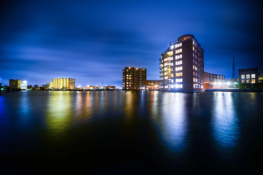 Modern waterfront apartment buildings at twilight with reflections